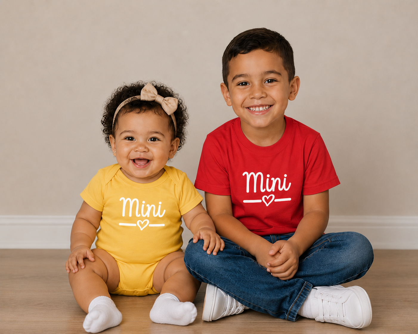 Two children sitting on the floor, one in a yellow outfit with 'Mini' and the other in a red shirt with 'Mini'.