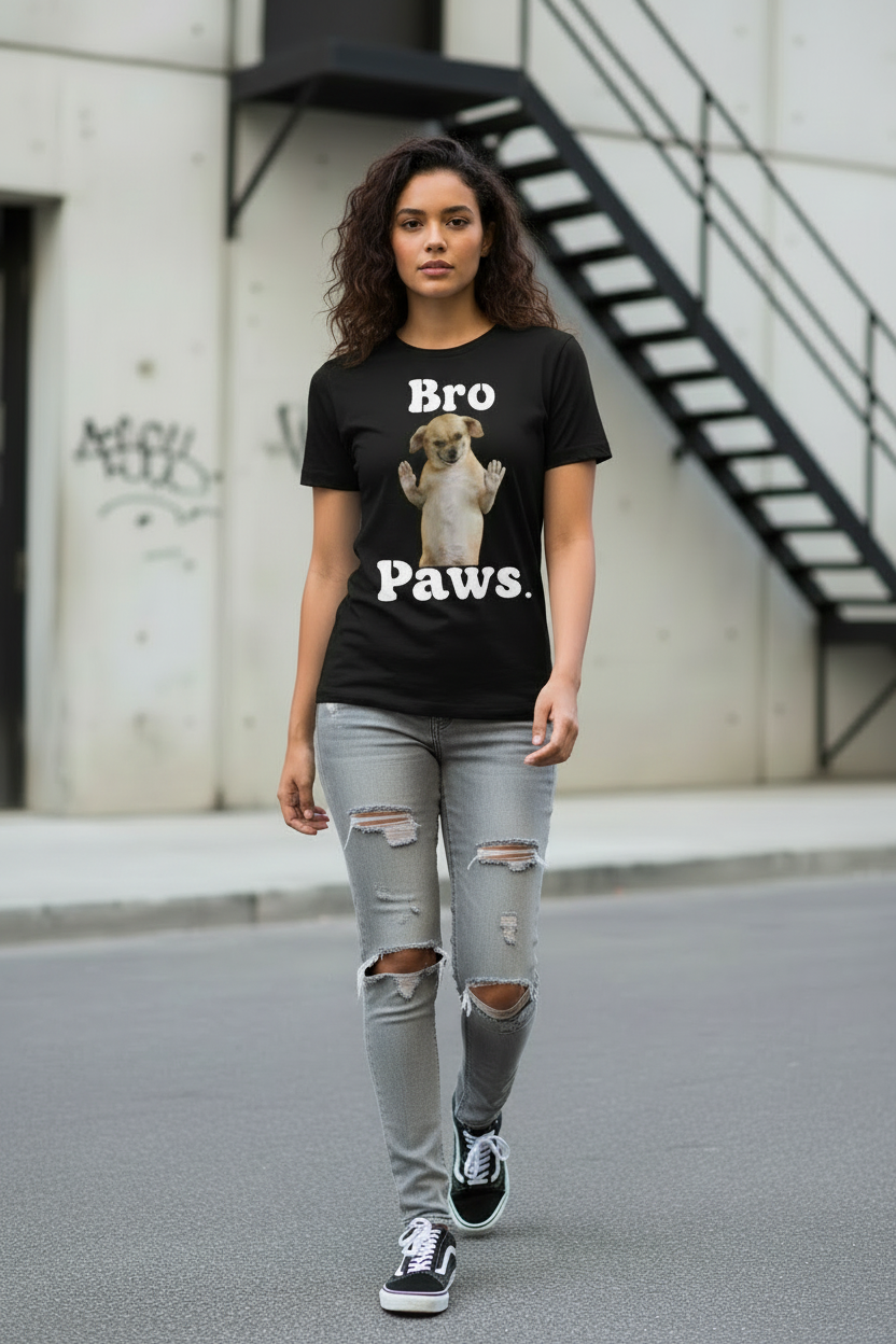 Person wearing a black t-shirt with a graphic and text, standing on a street.